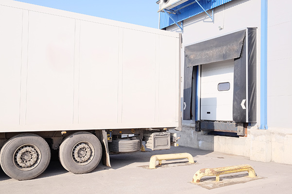 A box trailer parked outside of a loading bay.